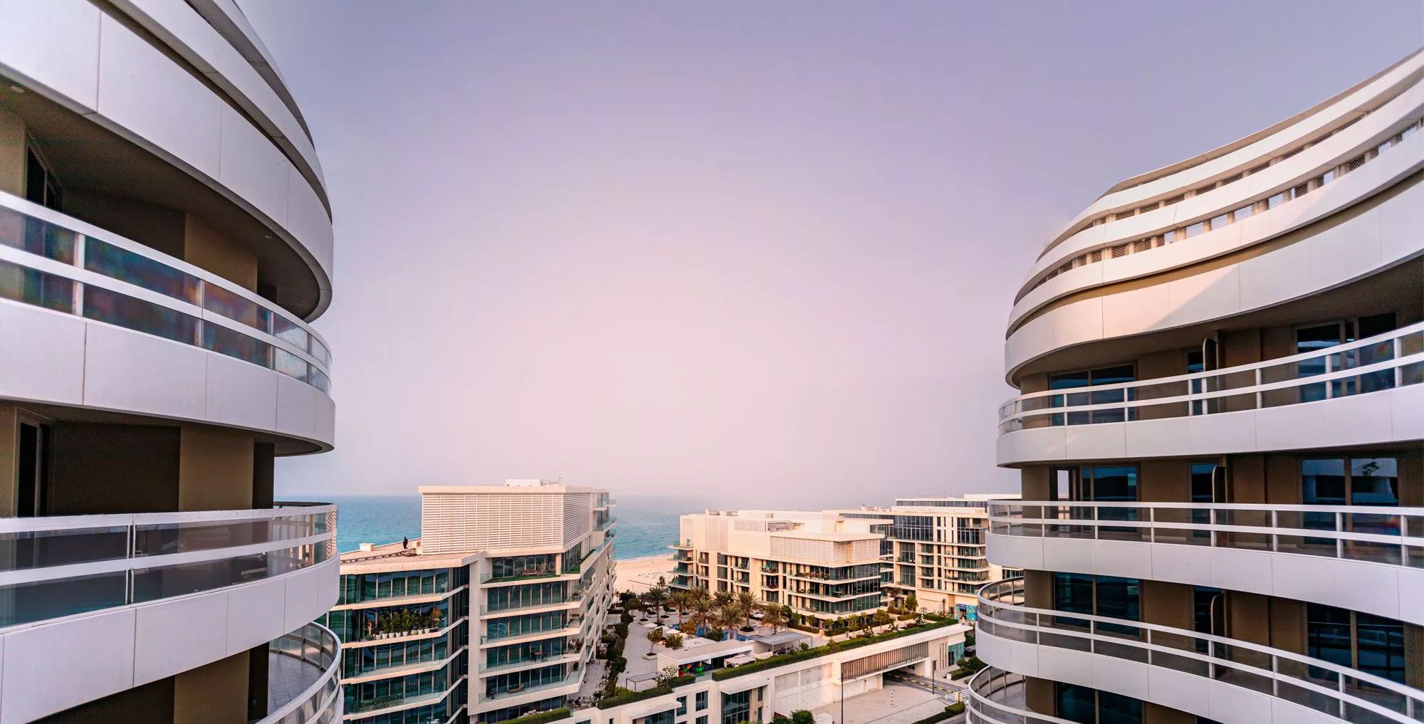 Modern facade of Ajwan Towers on Saadiyat Island with wave-like architectural curves and sea views in Abu Dhabi.